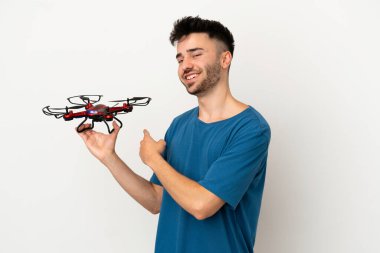 Beyaz arka planda izole edilmiş insansız hava aracı tutan adam geriye doğru işaret ediyor