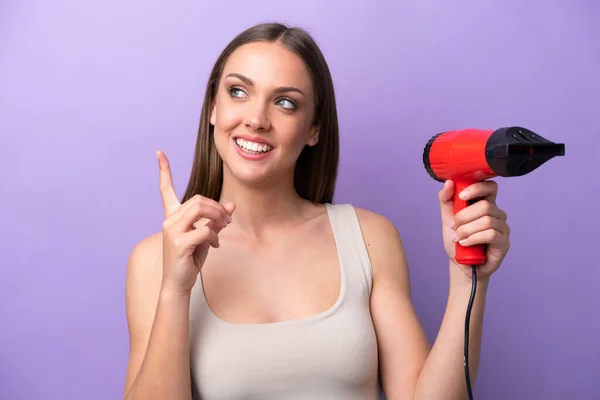 Young Caucasian Woman Holding Hairdryer Isolated Purple Background Intending Realizes — Stock Photo, Image