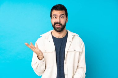 Mavi arka planda beyaz kadife ceketli genç yakışıklı şüpheli hareketler yapıyor.