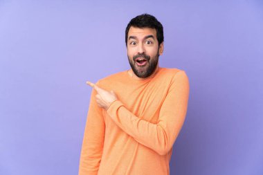 Kafkasyalı yakışıklı, soyutlanmış, mor bir geçmişi var. Şaşırmış ve işaret ediyor.