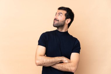 Kafkasyalı yakışıklı adam soyutlanmış arka planda gülümserken yukarı bakıyor.