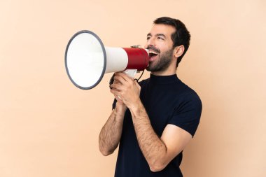 Kafkasyalı yakışıklı adam izole edilmiş arka planda megafondan bağırıyor.