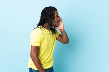 Beyaz arka planda, ağzı sonuna kadar açık bağıran örgülü Afro-Amerikan bir adam.