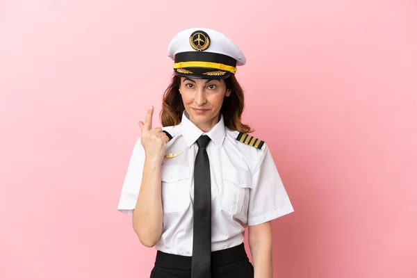 Αεροπλάνο Μεσήλικη Πιλότος Γυναίκα Απομονωμένη Ροζ Φόντο Δείχνοντας Δείκτη Μια — Φωτογραφία Αρχείου