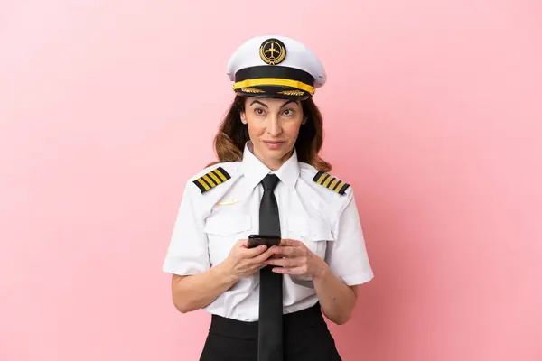 Αεροπλάνο Μεσήλικας Πιλότος Γυναίκα Απομονωμένη Ροζ Φόντο Έκπληκτος Και Στέλνοντας — Φωτογραφία Αρχείου