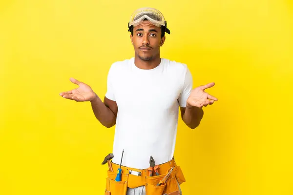 African American electrician man over isolated yellow wall having doubts while raising hands