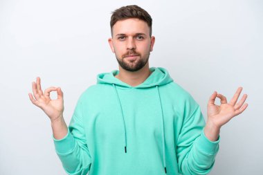 Beyaz arka planda Zen pozisyonunda beyaz tenli genç bir adam