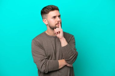 Kafkasyalı genç adam mavi arka planda izole edildi.