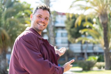 Açık havada genç beyaz bir adam.