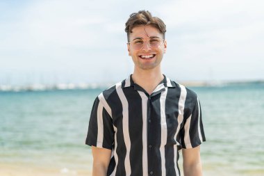 Neşeli gözlüklü genç yakışıklı adam.