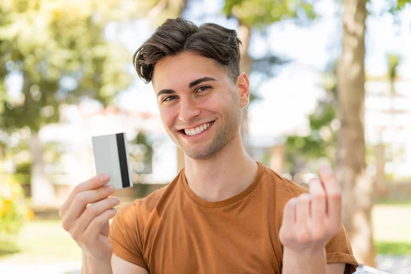 Mladý Pohledný Muž Držící Kreditní Kartu Dělá Peníze Gesto — Stock fotografie