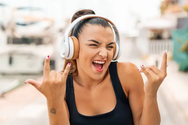 Молода Красива Жінка Відкритому Повітрі Слухає Музику Робить Рок Жест — стокове фото