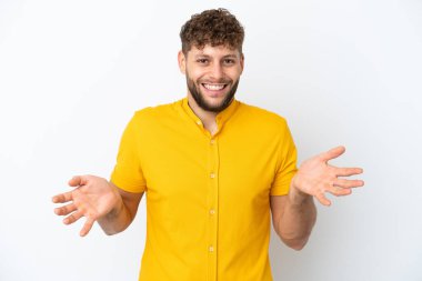 Beyaz arka planda izole edilmiş yakışıklı beyaz adam mutlu ve gülümsüyor.