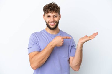 Beyaz arka planda izole edilmiş beyaz, yakışıklı beyaz bir adam bir ilan vermek için avuç içinde hayali bir fotokopi makinesi tutuyor.