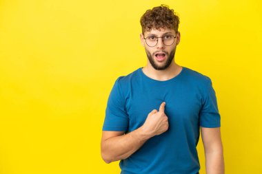 Sarı arka planda izole edilmiş yakışıklı beyaz adam kendini işaret ediyor.