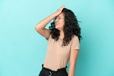 Mavi arka planda izole edilmiş genç Asyalı kadın bir şey fark etti ve çözüme niyetlendi.