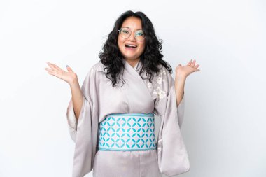 Kimono giyen genç Asyalı kadın beyaz arka planda izole edilmiş ve şok olmuş bir yüz ifadesi var.