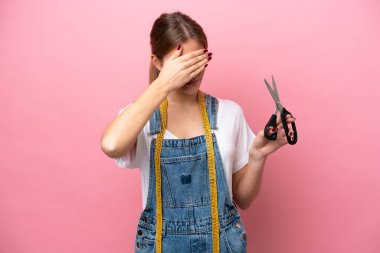 Pembe arka planda yalnız bırakılan beyaz kadın gözleri elleriyle kapatıyor. Bir şey görmek istemiyorum.