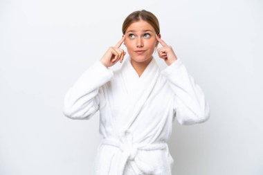 Bornozlu genç sarışın kadın beyaz arka planda izole edilmiş. Şüpheleri ve düşünceleri var.