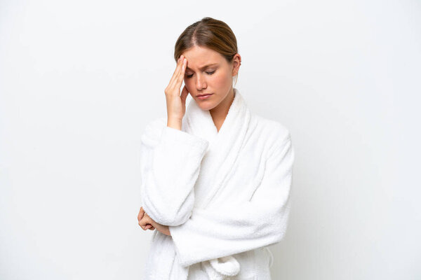 Young pretty blonde woman in bathrobe isolated on white background with headache