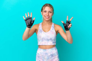 Beyaz kadın, mavi arka planda izole edilmiş, parmaklarıyla sekiz kişi sayıyor.