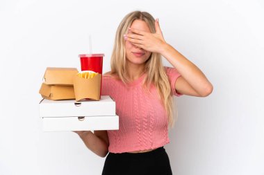 Mavi arka planda elleri ve gözlerini kapatan şişman yiyecekler tutan beyaz bir kadın. Bir şey görmek istemiyorum.