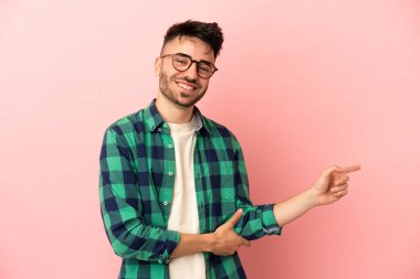 Pembe arka planda izole edilmiş genç, beyaz bir adam.