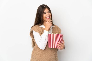 Beyaz arka planda izole edilmiş beyaz bir kadın elinde koca bir kova patlamış mısır tutuyor.
