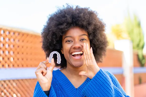 African American Girl Holding Invisible Braces Outdoors Shouting Mouth Wide — Stock Photo, Image