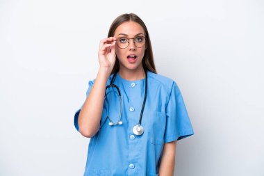 Young nurse caucasian woman isolated on white background with glasses and surprised