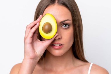 Beyaz arka planda avakado tutan beyaz bir kadın. Portreyi kapat