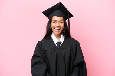 Kolombiyalı genç bir üniversite mezunu. Pembe arka planda izole edilmiş. Yüz ifadesi şaşırtıcıydı.