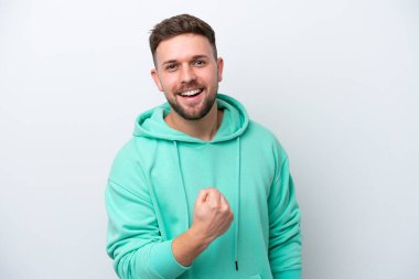 Beyaz arka planda izole edilmiş genç beyaz adam zaferi kutluyor.