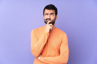 Kafkasyalı yakışıklı bir adam, soyutlanmış mor bir geçmişi var. Şüpheleri var ve kafası karışmış bir yüz ifadesi var.