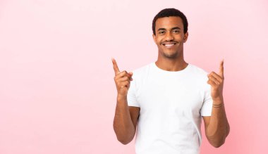 Telif uzayındaki Afrikalı Amerikalı adam pembe arka planda harika bir fikre işaret ediyor.