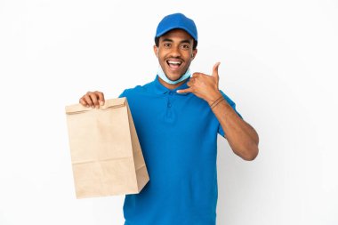 Beyaz arka planda izole edilmiş bir paket yiyecek alan Afro-Amerikalı bir adam telefon jesti yapıyor. Bana geri dönüş işareti ver.