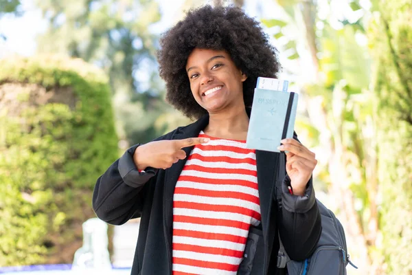African American Girl Holding Passport Outdoors Pointing — Stock Photo, Image