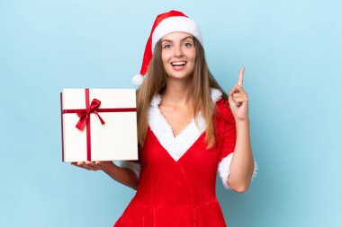 Anne Noel gibi giyinmiş, mavi arka planda izole edilmiş beyaz bir kadın harika bir fikre işaret ediyor.