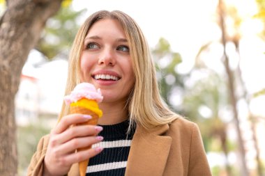 Açık havada kornet dondurmalı güzel sarışın kadın.
