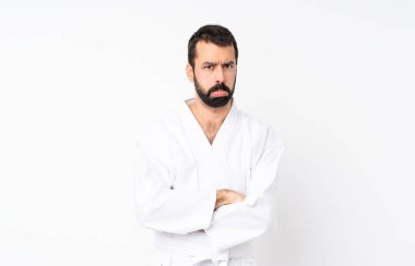 Karate yapan genç adam üzgün ve depresif bir ifadeyle izole edilmiş beyaz arka plan üzerinde