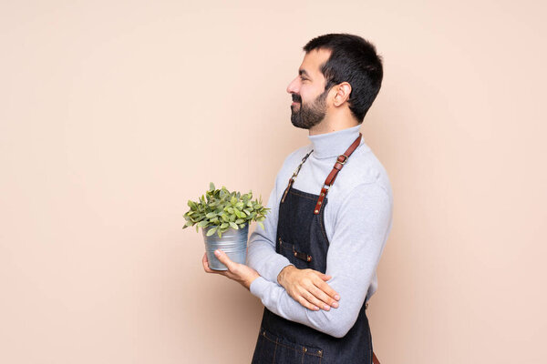 Man holding a plant over isolated background in lateral position