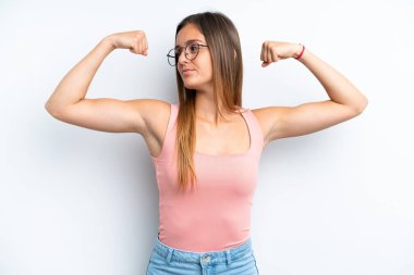 Beyaz arka planda izole genç beyaz kadın güçlü bir jest yapıyor.