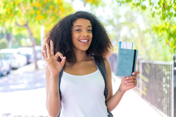 Young African American Woman Holding Passport Outdoors Showing Sign Fingers — Stock Photo, Image