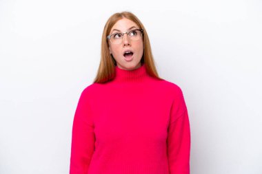 Genç kızıl saçlı kadın beyaz arka planda izole edilmiş yukarı bakıyor ve şaşırmış bir ifadeyle
