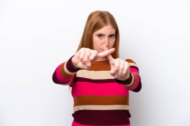 Beyaz arka planda izole edilmiş genç kızıl saçlı kadın bir hareketi durdurmak için elleriyle hareket yapıyor.
