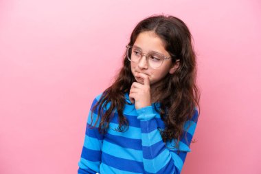 Küçük kız pembe arka planda gözlüklü ve kuşkuları olan