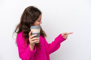 Beyaz arka planda izole edilmiş beyaz bir kahve taşıyan küçük beyaz bir kız bir ürünü sunmak için kenarı işaret ediyor.