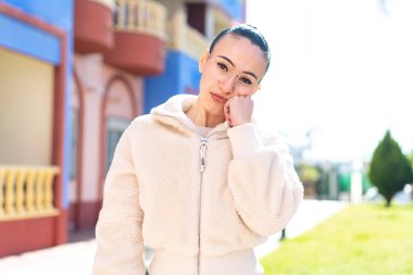 Dışarıdaki Faslı genç bir kız Gözlüklü ve üzgün bir ifadeyle