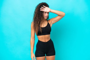 Genç Arap kadın yorgun bir ifadeyle mavi arka planda izole edildi