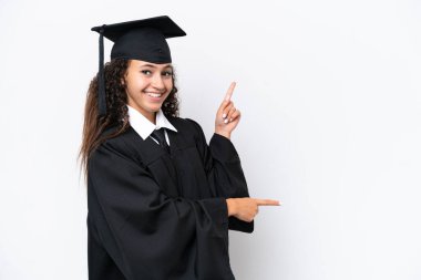 Üniversite mezunu genç bir Arap kadın beyaz arka planda izole edilmiş bir şekilde parmak ucunda bir ürün sunuyor.